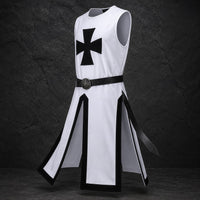 Variante blanche de la Tunique du Chevalier Templier en polyester avec croix noire, vue en angle sur fond pierre sombre.