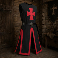 Tunique du Chevalier Templier en polyester noir avec croix rouge, présentée de face sur fond pierre claire.